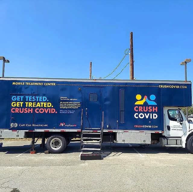 Navy blue CRUSH COVID mobile treatment center trailer with Get Tested, Get Treated messaging