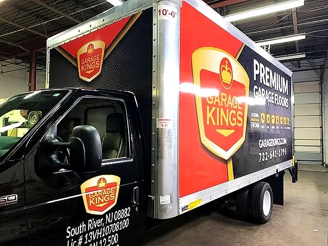 Black box truck wrapped with the gold Garage Kings crest logo and Premium Garage Floors branding, South River NJ